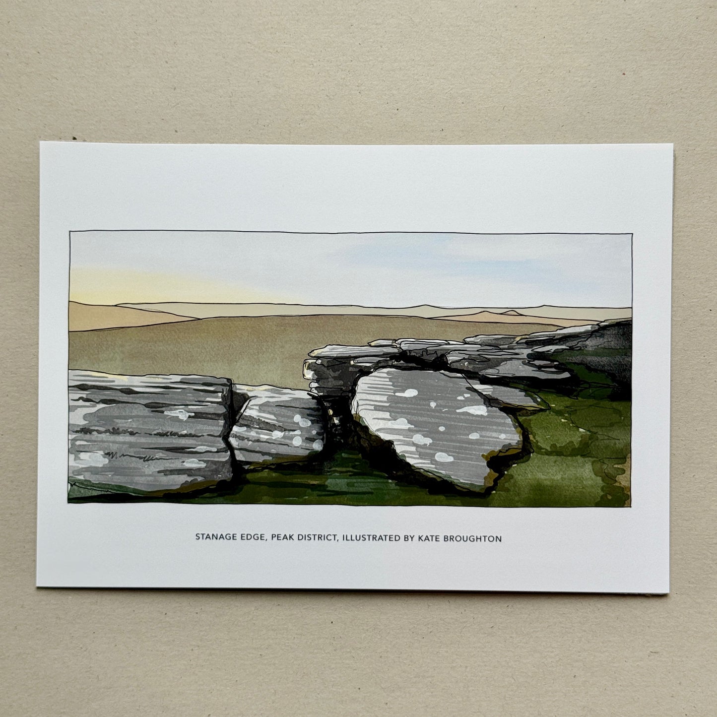 Print of a landscape with stone structures on a beige background. Labelled: Stanage edge Peak District, illustrated by Kate Broughton