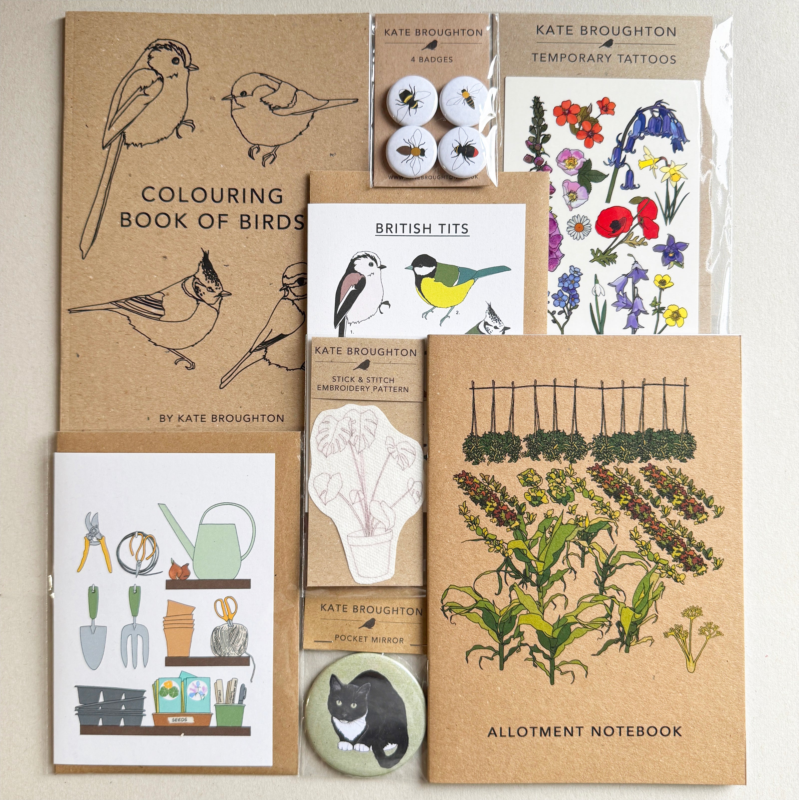 Collection of nature-themed illustrated products including a coloring book, tattoos, cards and notebooks on a neutral background.
