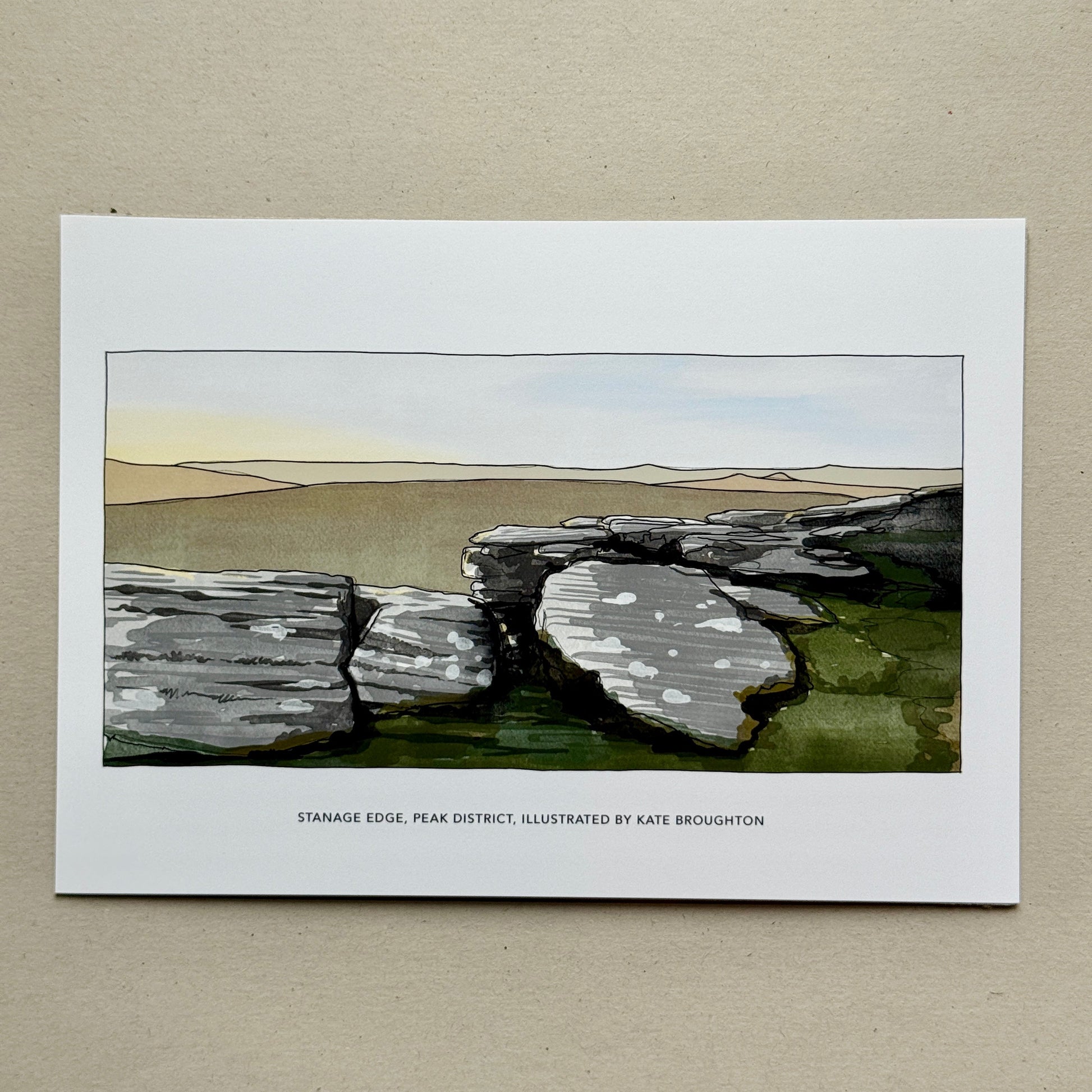 Print of a landscape with stone structures on a beige background. Labelled: Stanage edge Peak District, illustrated by Kate Broughton