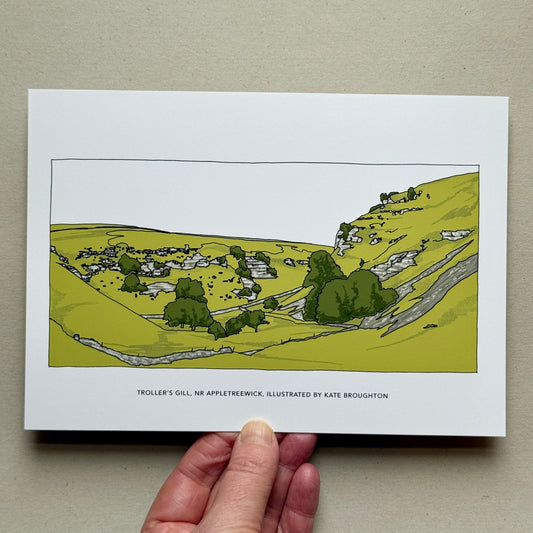 Hand holding Illustration of a landscape with greenery and dry stone walls. Labelled Troller's Gill, Nr Appletreewick, Yorkshire