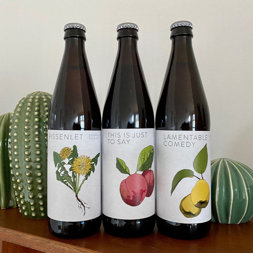 Three bottles of beer with labels featuring illustrations of flowers and fruits by Kate broughton