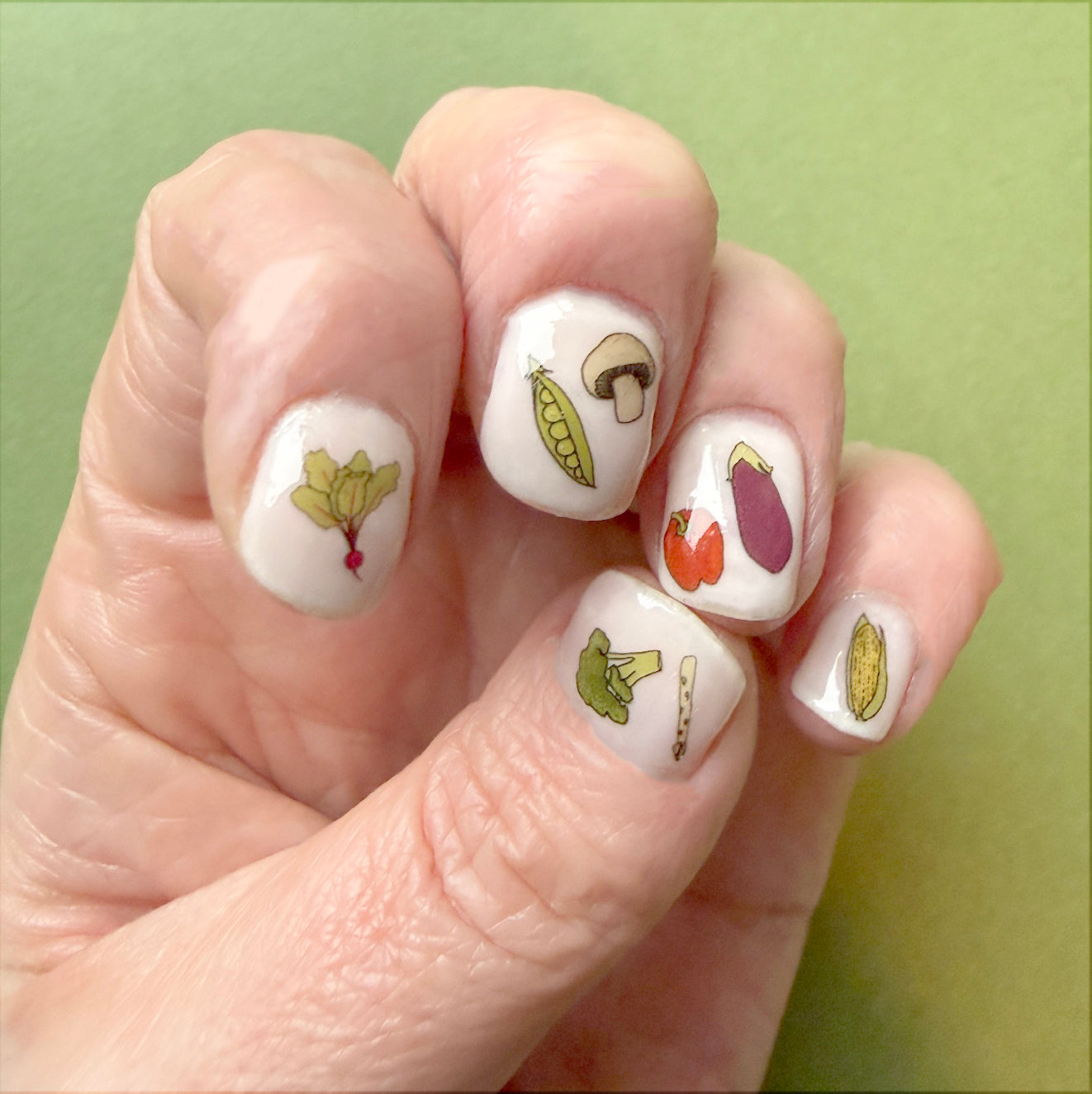 vegetable nail art transfers over pale nail varnish - hand drawn veg illustrations by Kate broughton